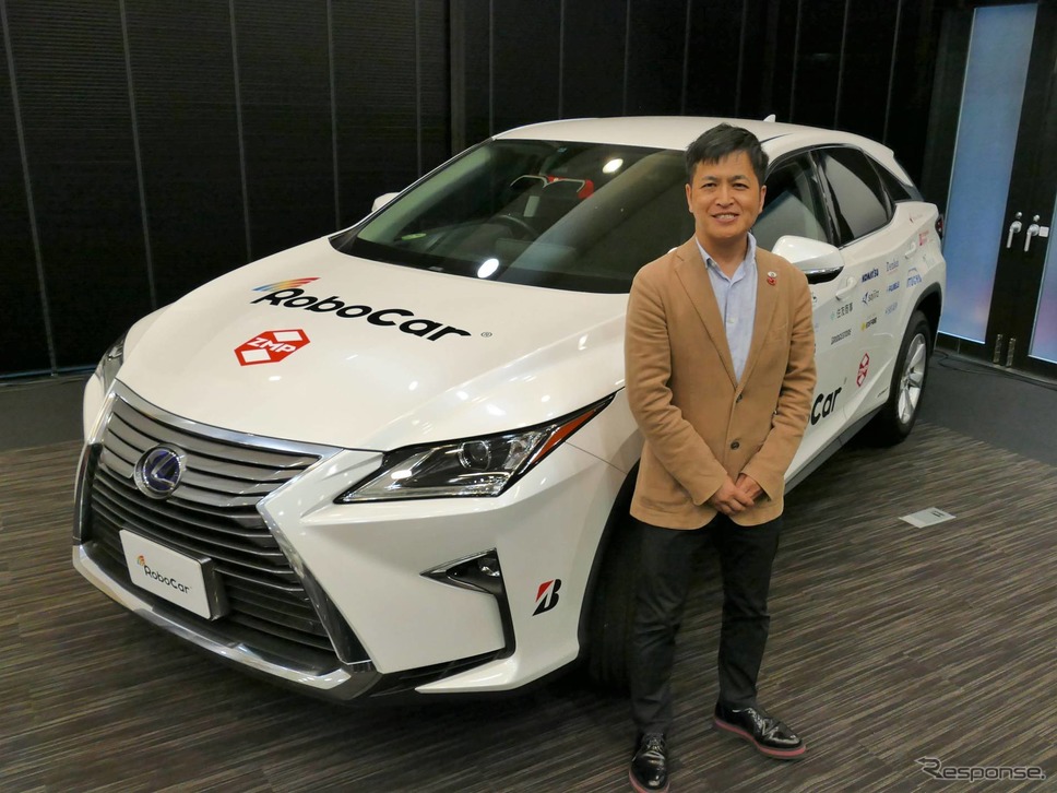 ZMP 代表取締役社長の谷口恒(たにぐちひさし)氏とRoboCar SUV《撮影 佐藤耕一》