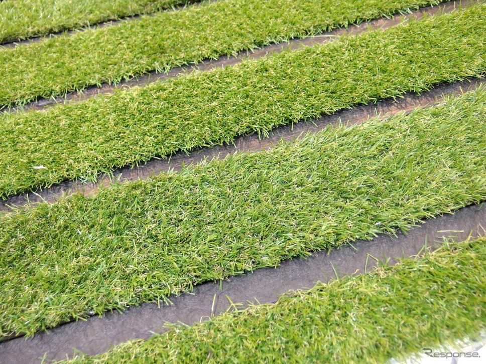 昭和造園土木のタフグリーンは、芝生に必要な土の厚さ15cmを確保した駐車場の芝生保護材（芝生駐車場）だ。写真の芝はさんぷるの人工芝。《撮影 高木啓》