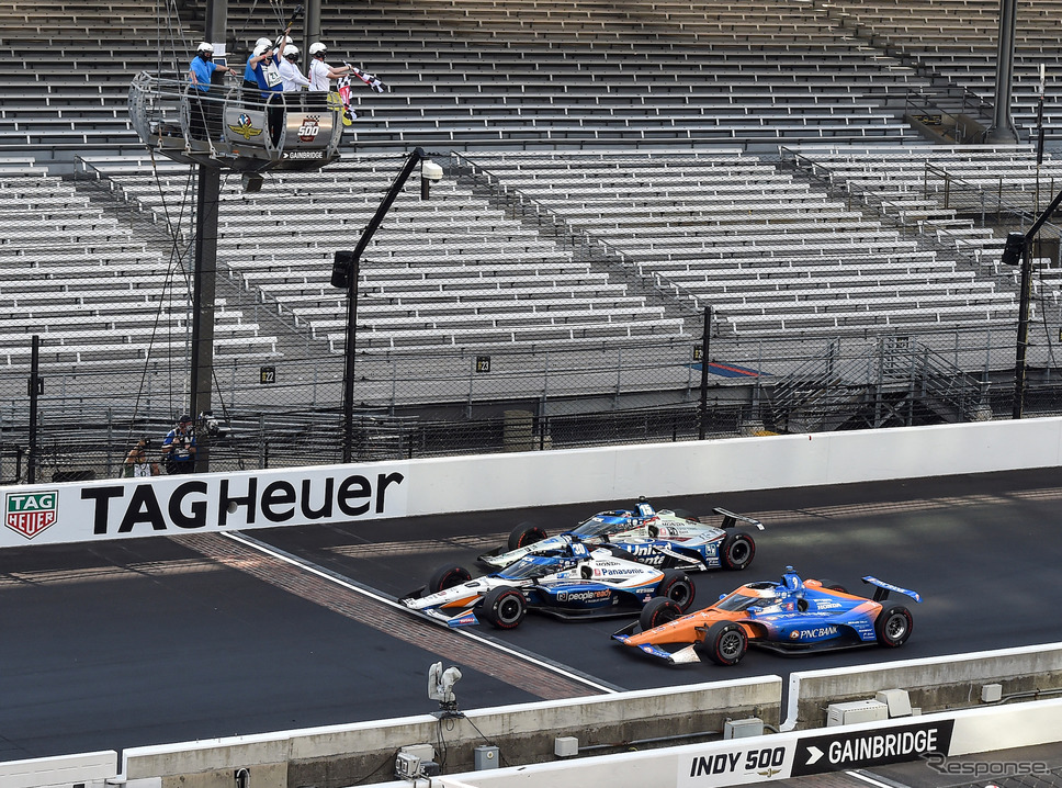 8月の無観客開催となったインディ500、#30 佐藤琢磨(中央)がイエローコーション下でのトップチェッカーを受ける。《写真提供 INDYCAR》