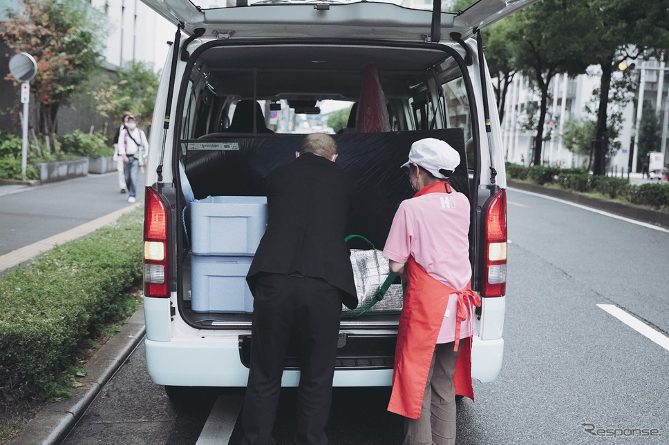 お弁当を荷台に詰め込む《写真撮影 坂本貴史》