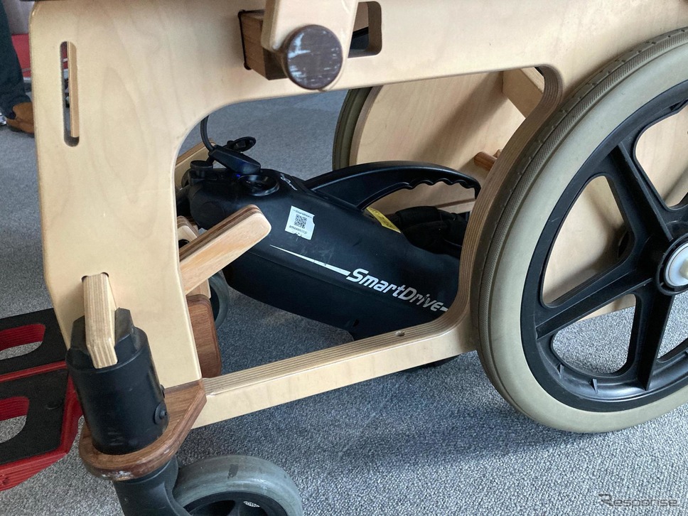 木製車いすに装着した電動アシストユニット「スマートドライブ」《写真提供 JAL》