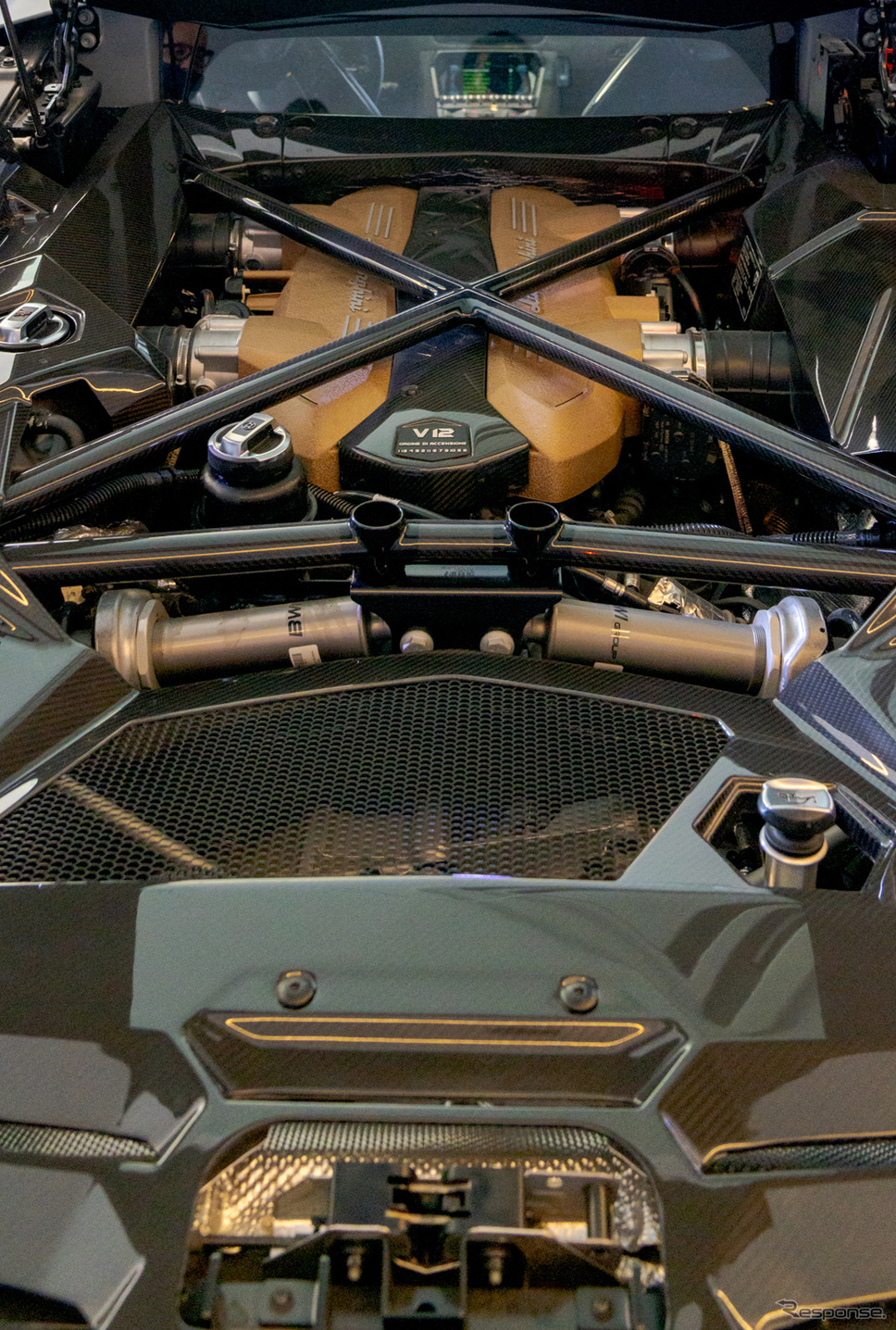 手前にはシルバーのプッシュロッド式磁気レオロジー・アクティブ・リアサスペンションが見える。奥にはV12自然吸気エンジンが鎮座する。《写真撮影 関口敬文》
