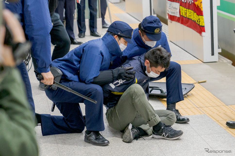 消防隊が控えているため、不審者は速やかに連行される。《写真撮影 関口敬文》