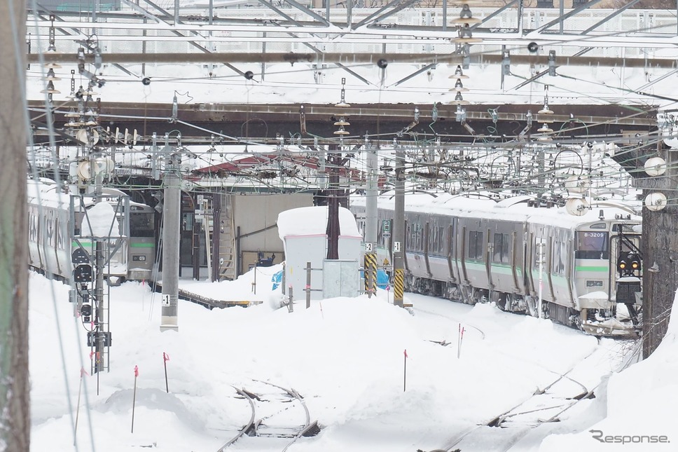 雪に埋もれるようにホームに佇む電車。2022年2月22日、函館本線小樽駅。《写真撮影 佐藤正樹》