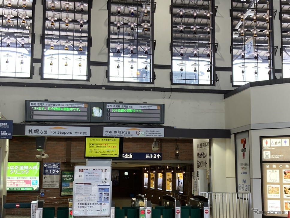 終日運休を伝える小樽駅の改札口。その上を除雪機械が通過していく。2022年2月22日、函館本線小樽駅。《写真撮影 佐藤正樹》