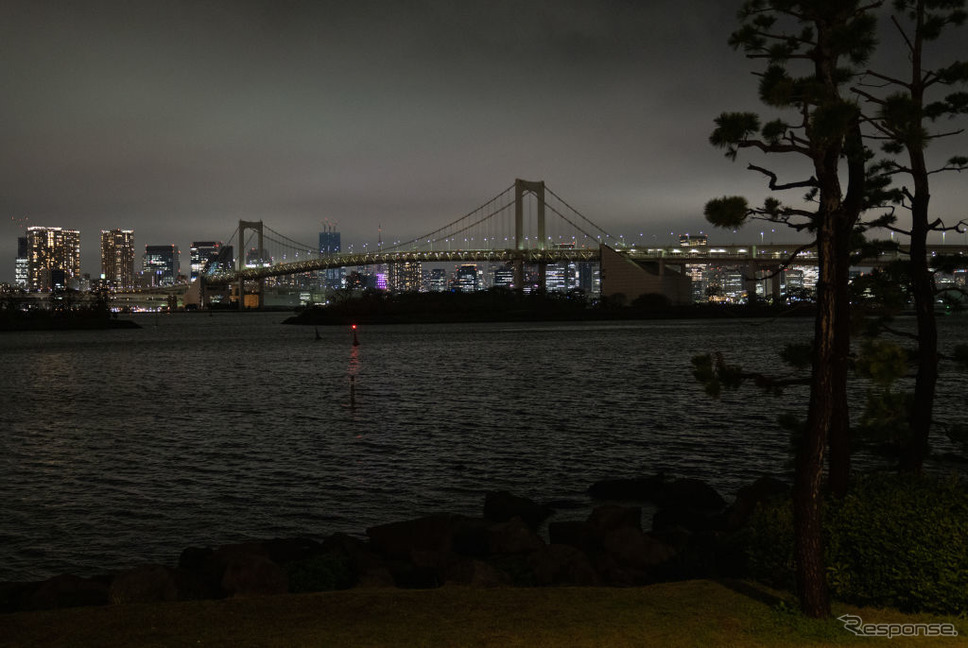 節電する東京：ライトアップを消灯したレインボーブリッジ。臨海都心も暗い（3月22日）《Photo by Carl Court/Getty Images News/ゲッティイメージズ》