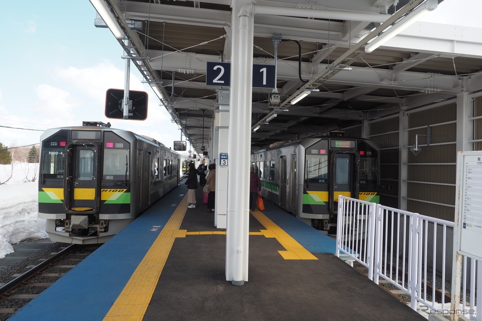 2021年10月に移設された函館本線倶知安駅の在来線ホームで発車を待つH100形の普通列車。3Qでは同車の観光列車化が予定されている。2022年4月2日。《写真撮影 佐藤正樹》