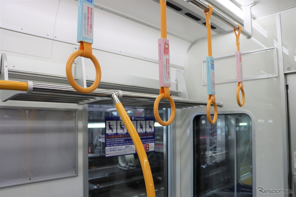 オレンジ色となった優先座席部の吊り手と手すり。一般座席部との違いをわかりやすくした。《写真提供 大阪市高速電気軌道》