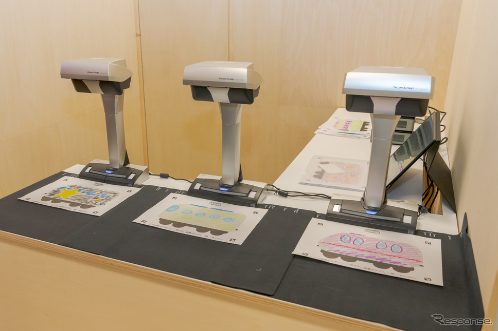 色を塗った電車はスキャナーで読み込まれる。《写真撮影 関口敬文》