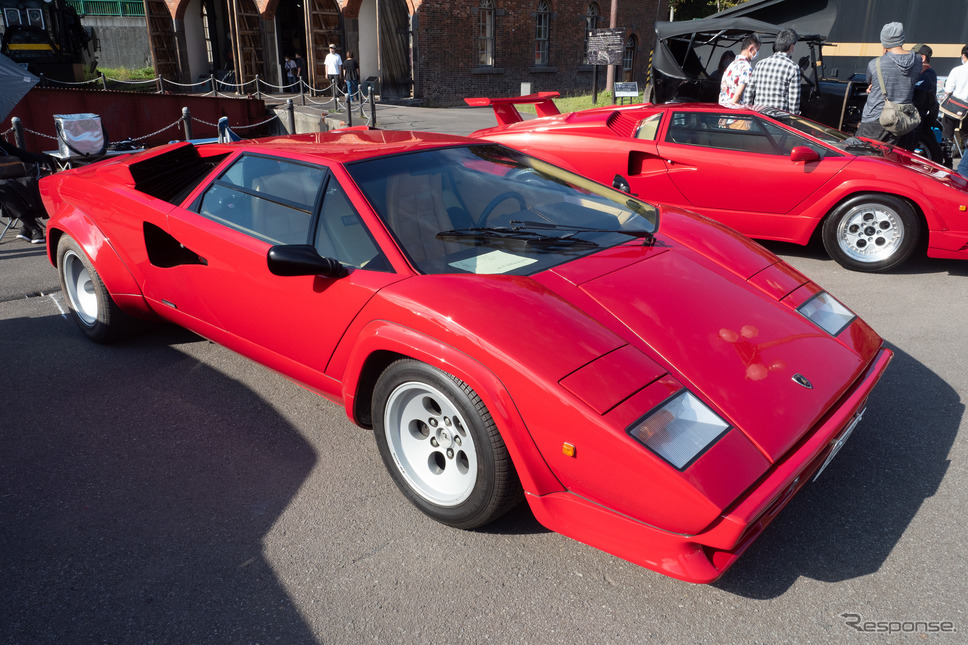 「T型フォード」と並ぶ形で2台が鎮座する赤い『カウンタック』。奥が25周年のアニバーサリーモデル（1989年）。《写真撮影 佐藤正樹》