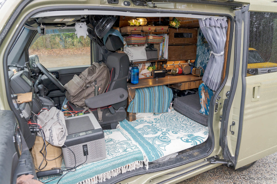 車体の半分をテーブルを含めた家具で占める。手前は座るスペースと寝るスペースを兼用。《写真撮影 関口敬文》