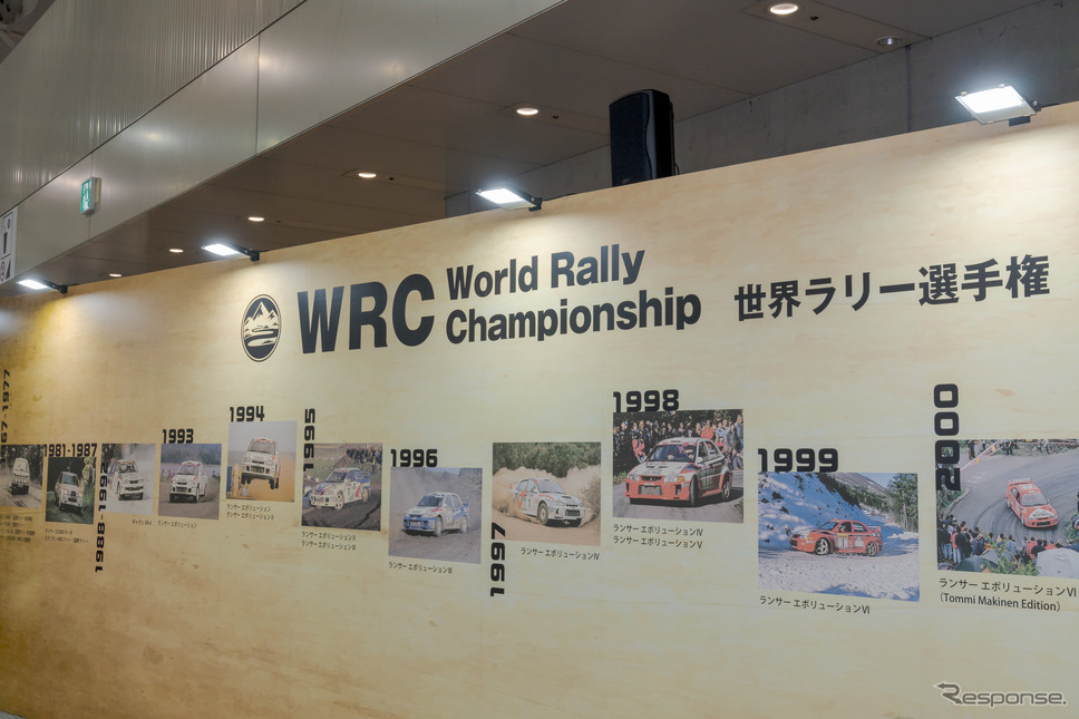 三菱自動車工業のブースの壁にはWRCに参戦した車の写真がズラリと並んでいた。《写真撮影 関口敬文》