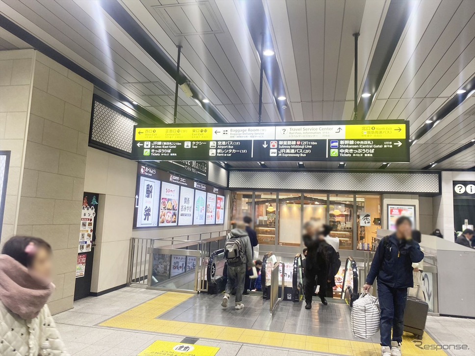 ［新大阪駅設置個所、経路案内］2階への下りスカレーターにのる《写真提供 エムケイホールディングス》